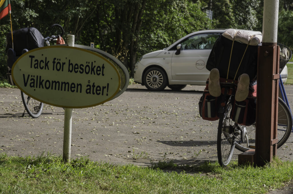 Bild av parkering med cyklar och skylt med texten: Tack för besöket Välkommen åter!